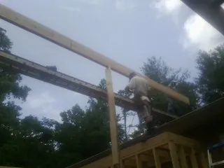 Carpenter setting a ridge beam over a new addition frame — Ice Dam Removal by Roofing Brothers in Hillsdale