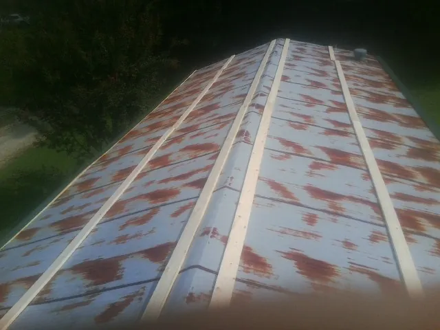 Rusted metal roof panels with new wood purlins before replacement — Storm Damage Roof Repair in Hillsdale by Roofing Brothers