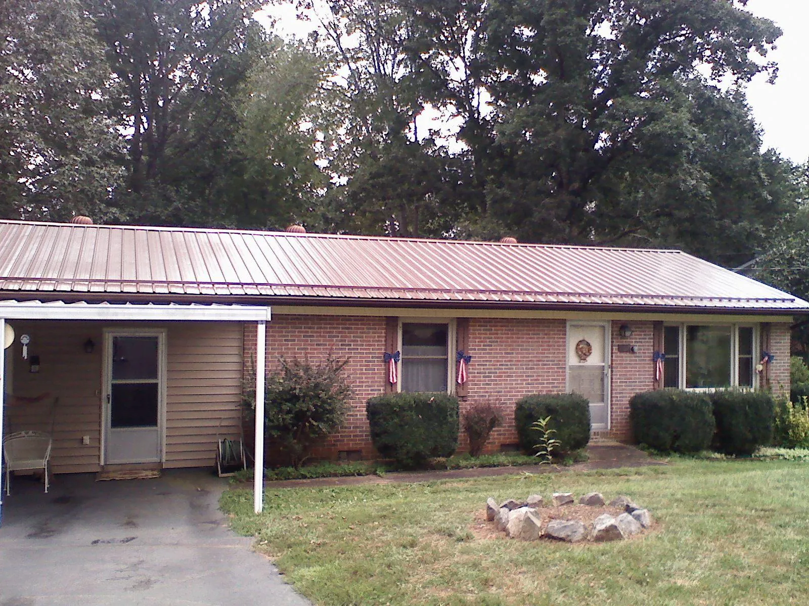 Bronze metal roof and carport on a brick ranch home — Roof Repair work by our crew in Hillsdale