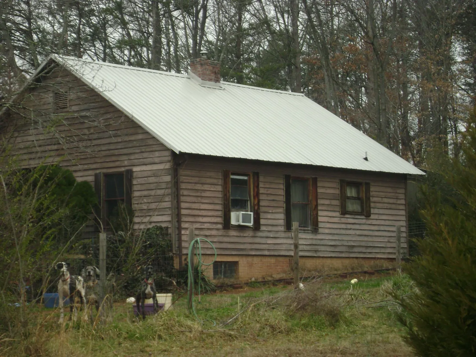 White metal roof on an old wood sided farmhouse, from a Metal Roof Installation job in Hillsdale